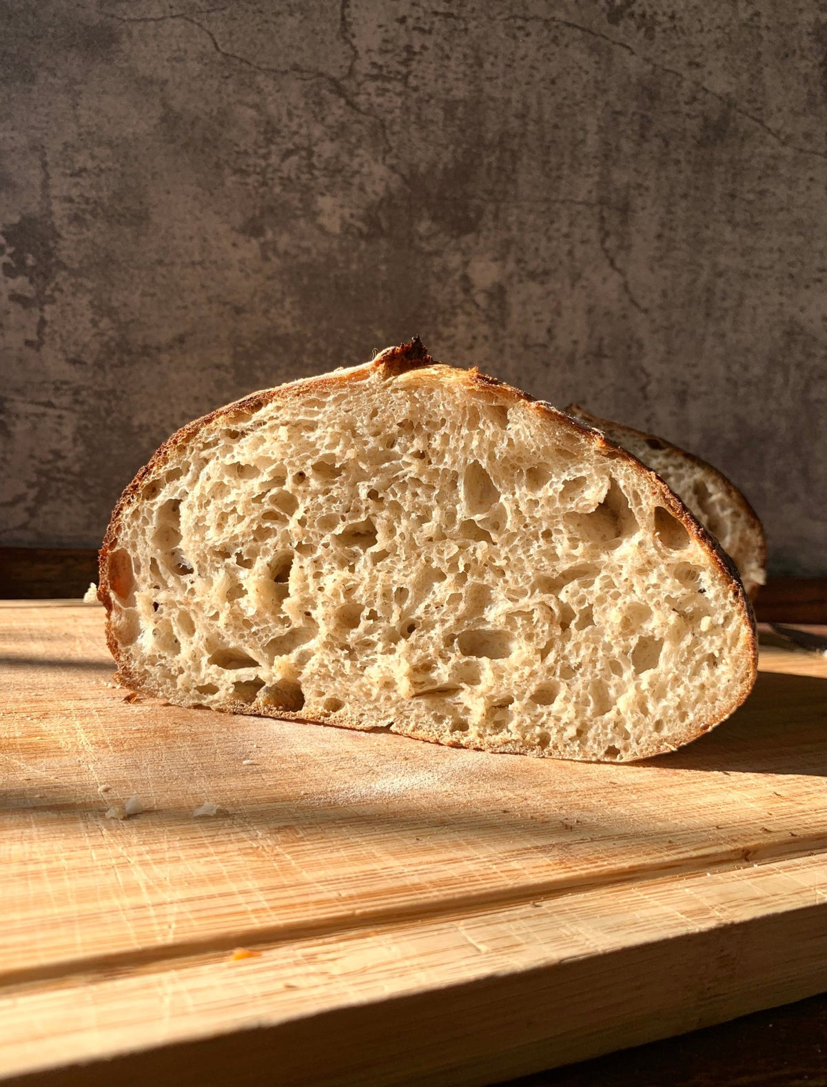 Cross section of a Rise Artisanal classic sourdough boule showing an open crumb